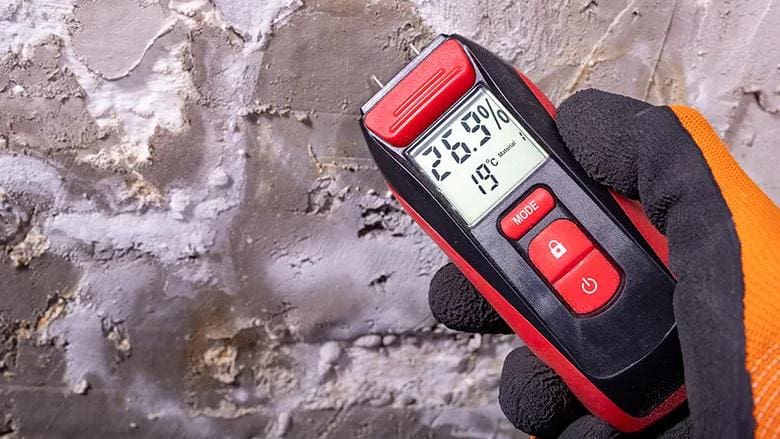 moisture meter detecting water leak in wall with high humidity reading